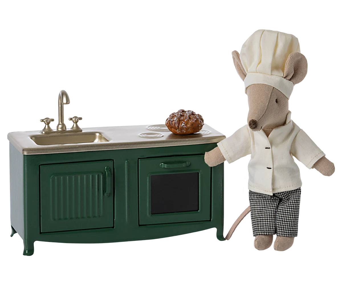 Toy mouse in chef outfit next to small kitchen set