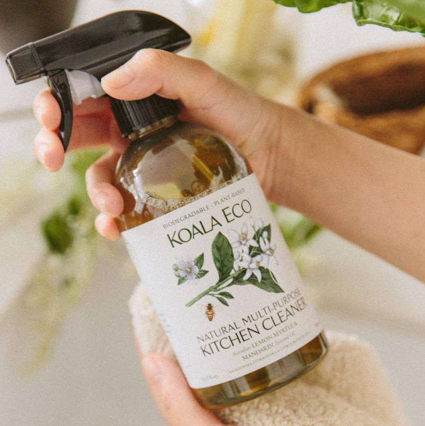A spray bottle of Koala Eco Natural Multi-Purpose Kitchen Cleaner with a label featuring lemon myrtle and mandarin illustrations.