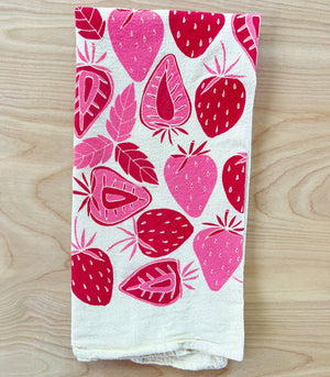 A white kitchen towel with a silkscreened red strawberry pattern.