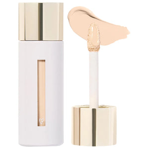 Cosmetic concealer with applicator and swatch on a white background