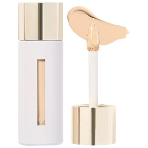 Cosmetic concealer with applicator and swatch on a white background