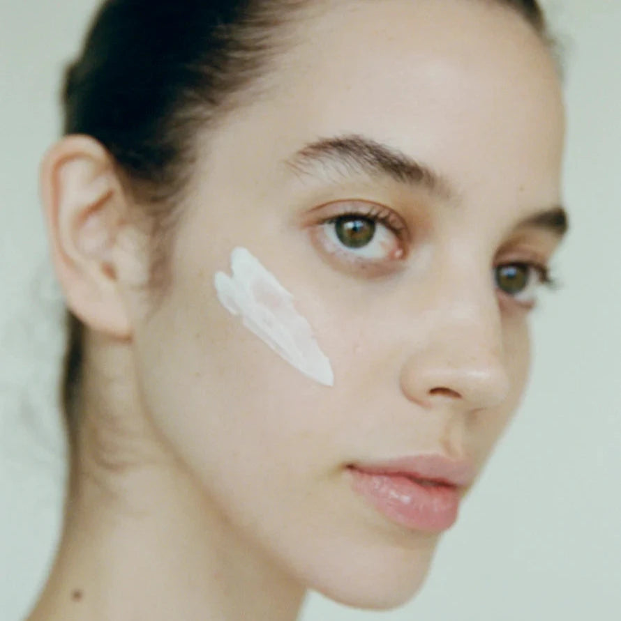 Lesse essential moisturizer applied to a woman's cheek