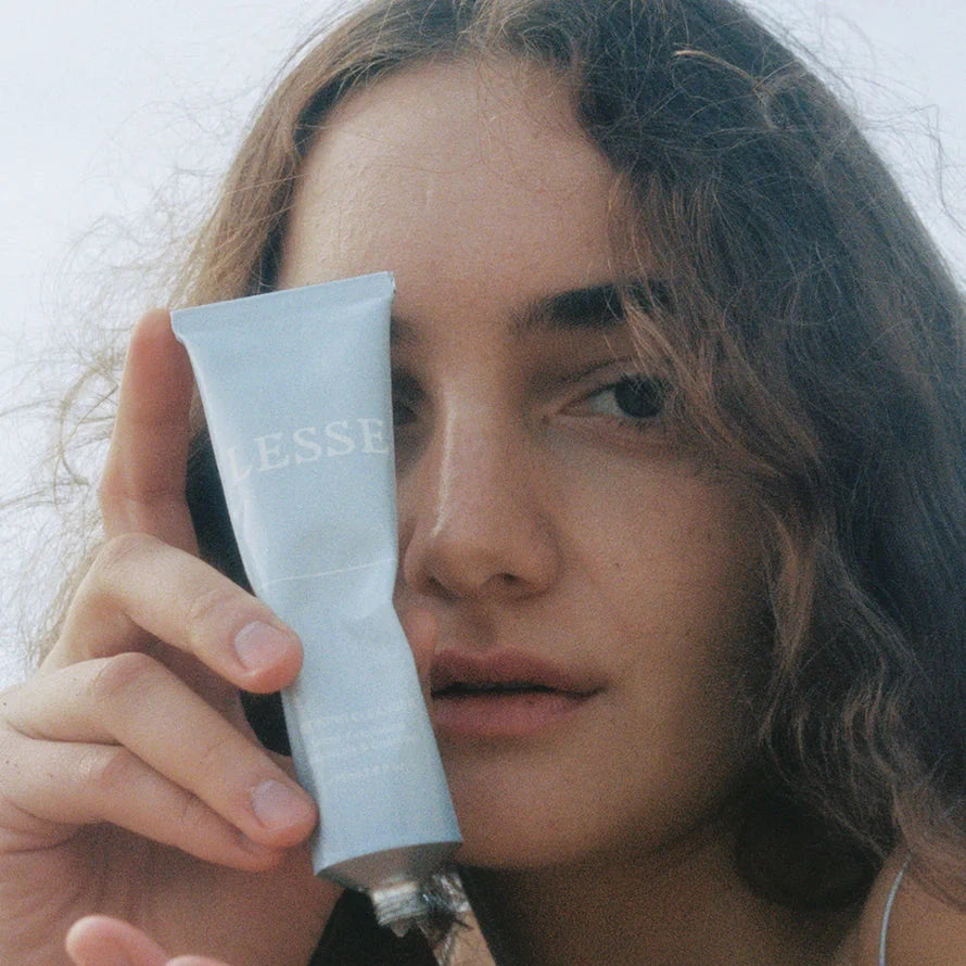 A person holding a tube of Lesse refining cleanser