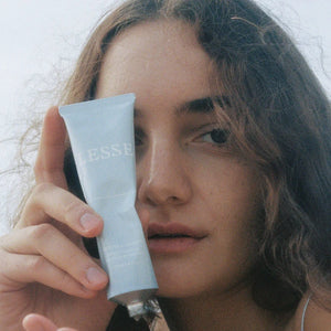 A person holding a tube of Lesse refining cleanser