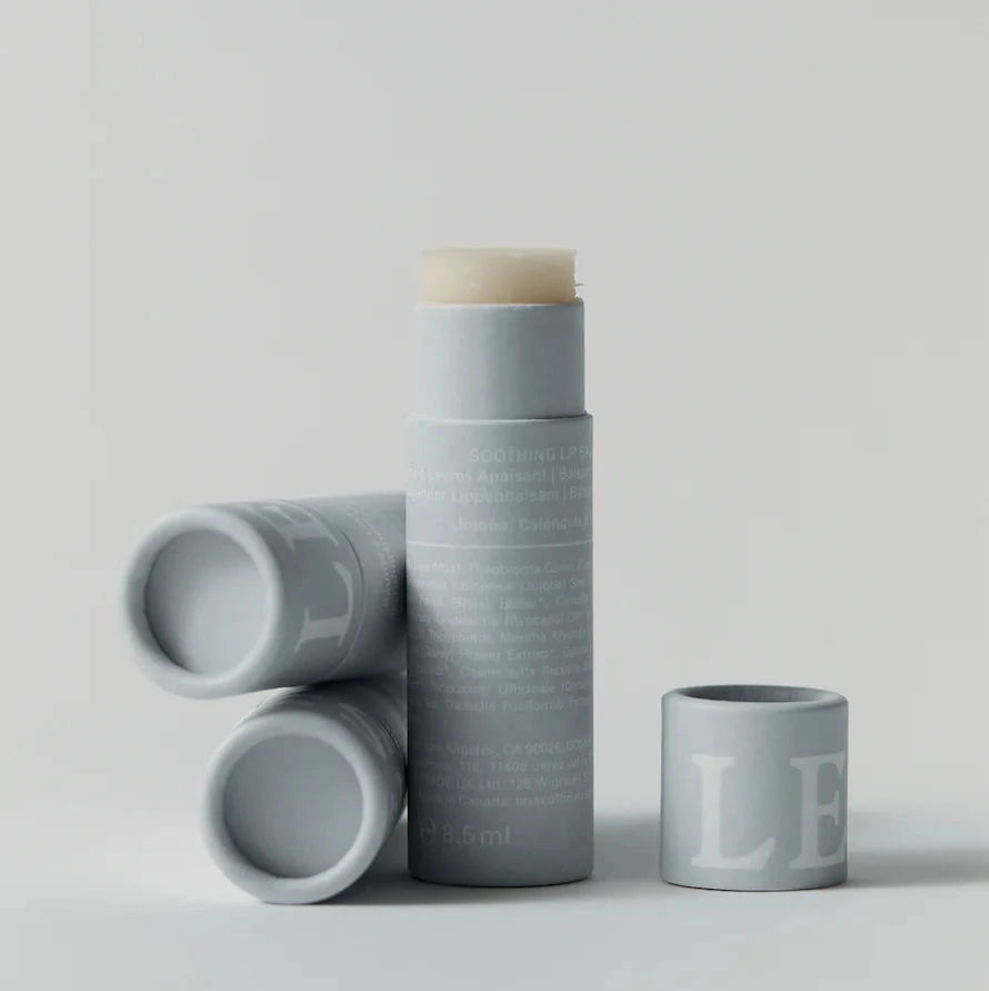 A tube of soothing lip balm, with two uses lying beside it