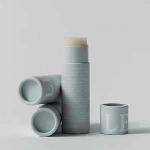 A tube of soothing lip balm, with two uses lying beside it