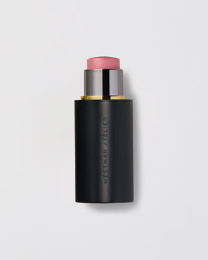 A lit up highlight stick with a black casing and a pinkish highlighting product visible at the top.