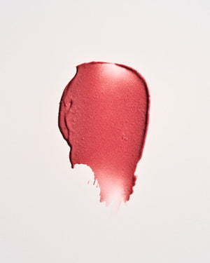 Pink lipstick swatch on a light pink background