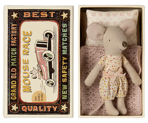 A toy mouse in a matchbox with the text 'Best Quality' on the cover, dressed in a polka dot outfit.