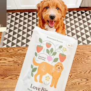 A bag of love bites dog treats, made by botanical bones, and a happy dog