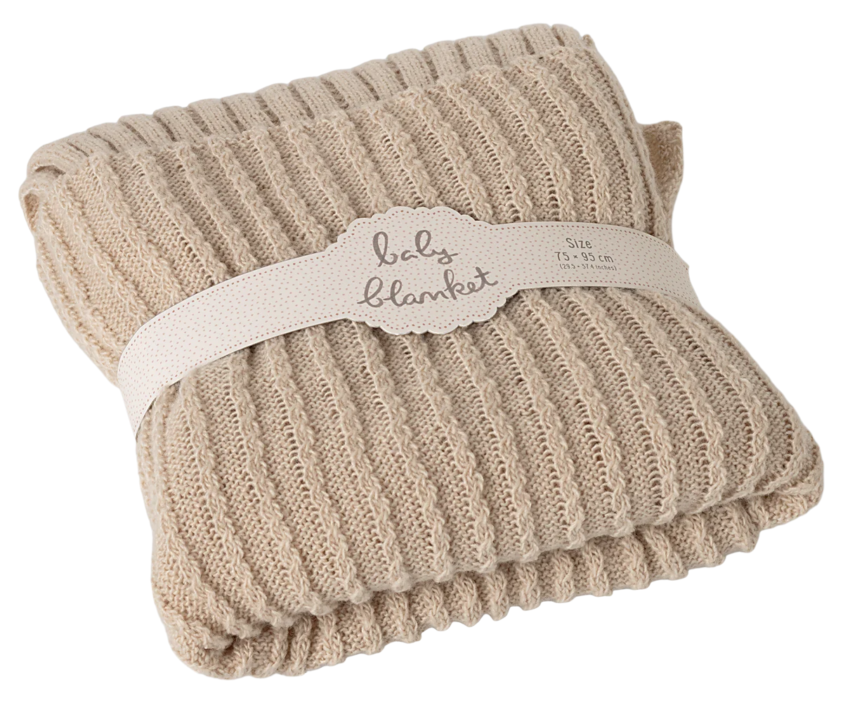 Beige baby blanket with a label on a white background