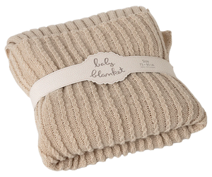Beige baby blanket with a label on a white background