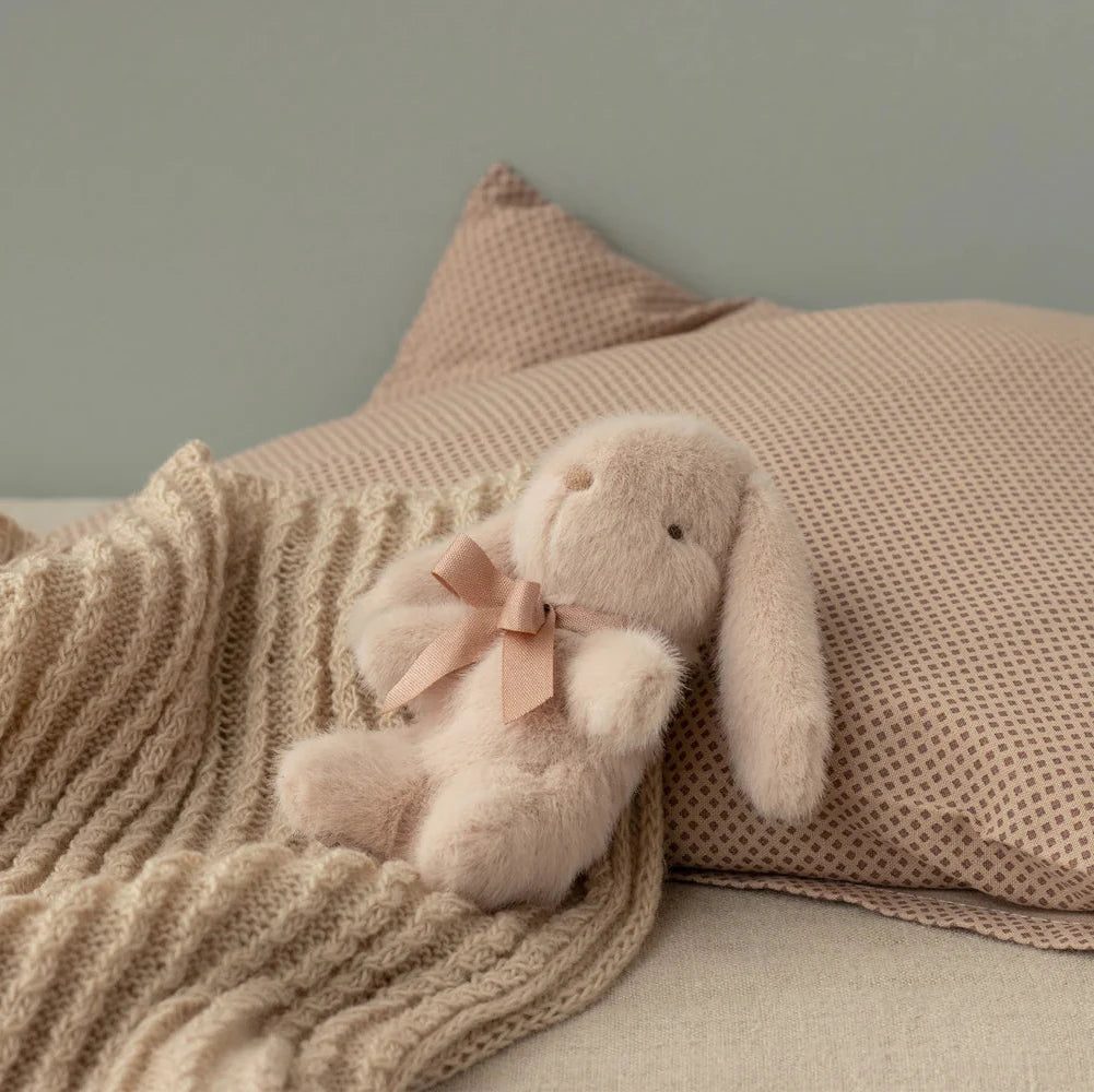 Beige baby blanket with a label on a white background