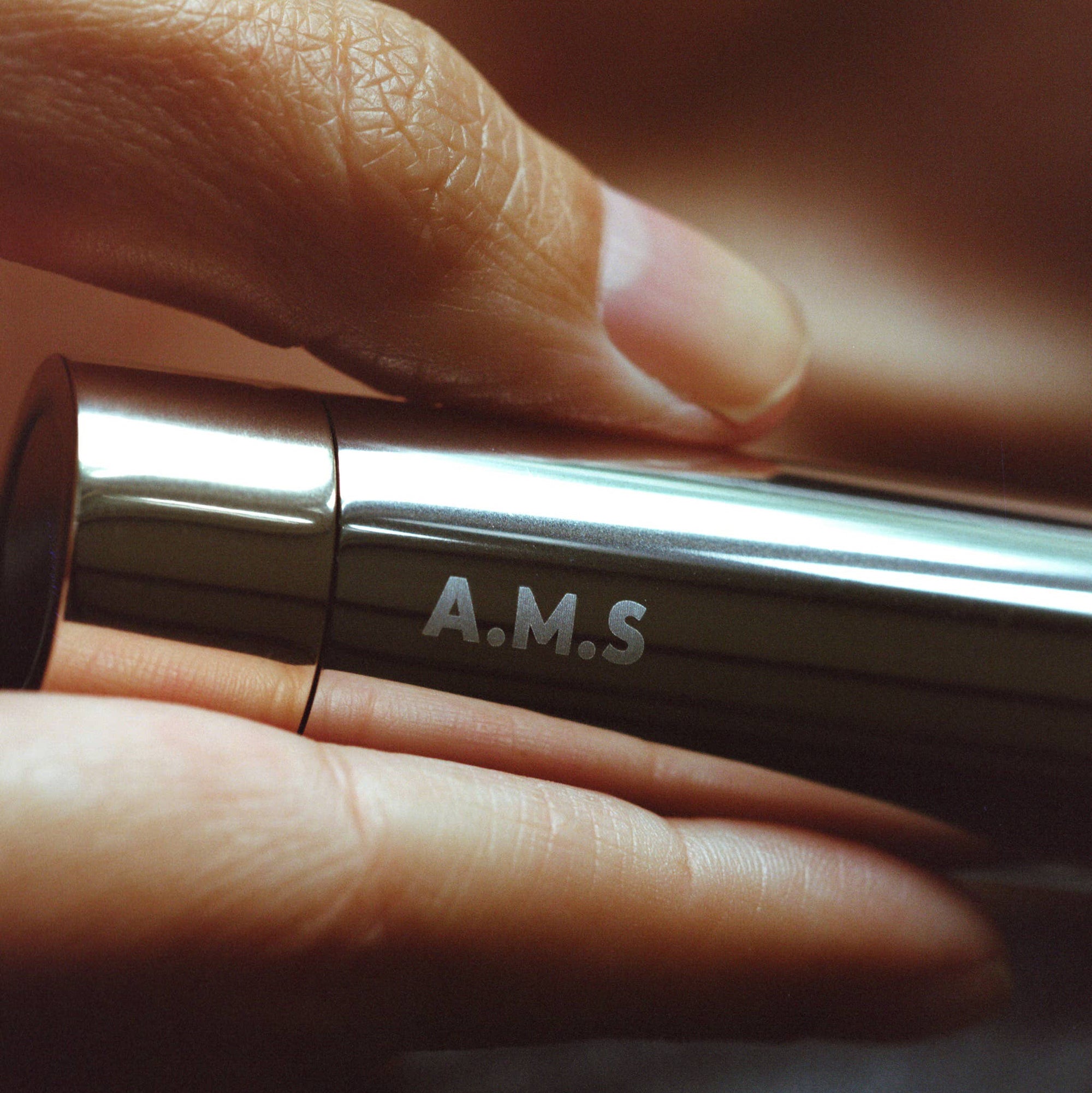 A.M.S lip balm with orange packaging on a white background