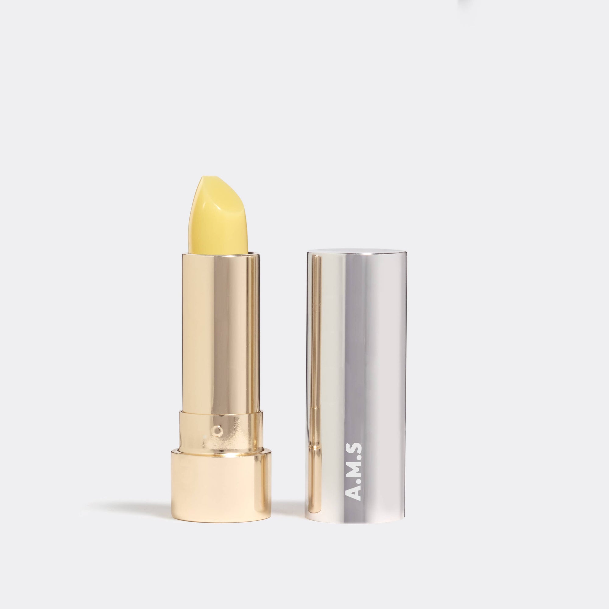 Yellow lipstick with silver case on a white background