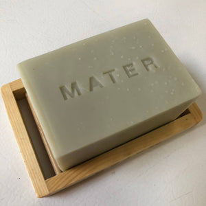 A mater kitchen soap block on a bamboo soap holder marked MATER. 