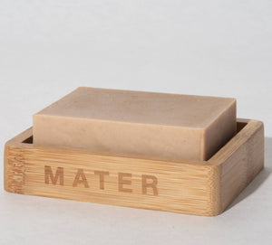 A mater kitchen soap block on a bamboo soap holder marked MATER. 