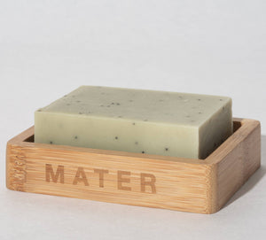 A mater kitchen soap block on a bamboo soap holder marked MATER. 