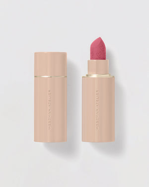 A single matte lipstick stick with the cap off, showing a pink color bullet. The packaging is sleek and refillable with a magnetic mirrored cap.
