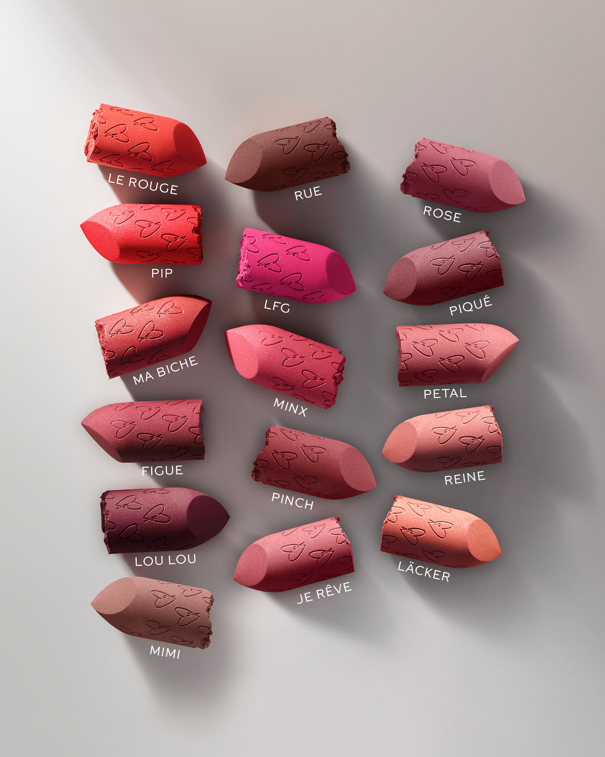 Collection of red lipstick shades on a light gray background