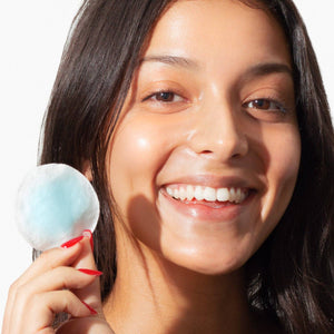 Woman applying sunscreen cream to her face.