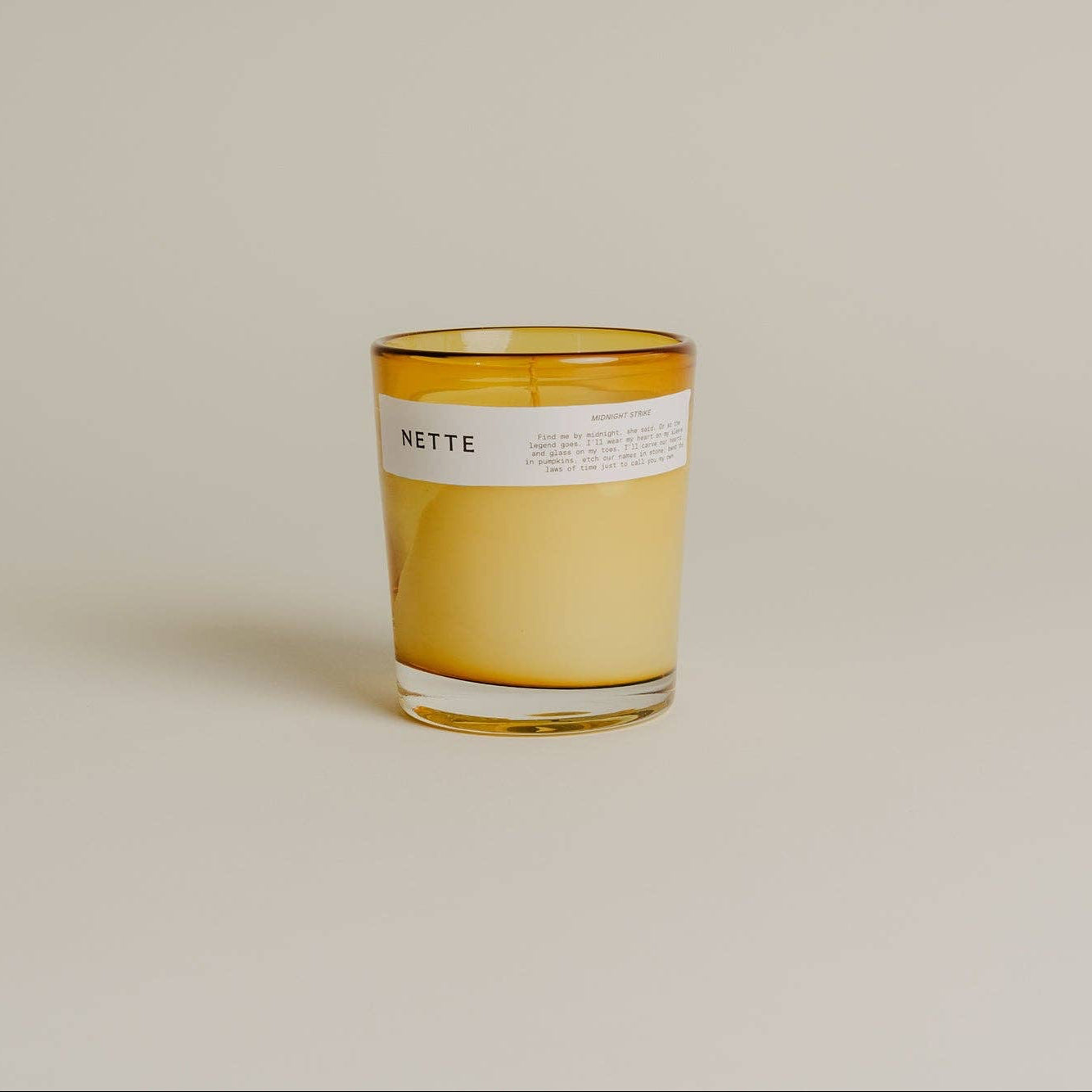 Candle with a label on a beige background