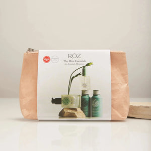 Cosmetic bag with Röz branding and product images on a beige background