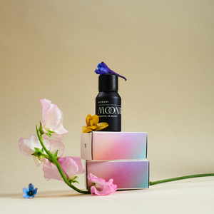 Black bottle labeled 'MOONBEAM' with flowers on a beige background