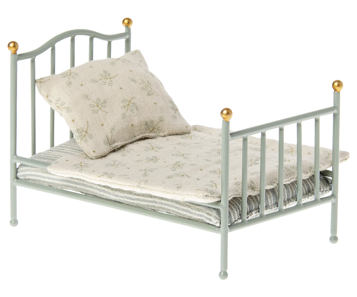 Small toy bed with a pillow on a white background