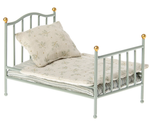 Small toy bed with a pillow on a white background