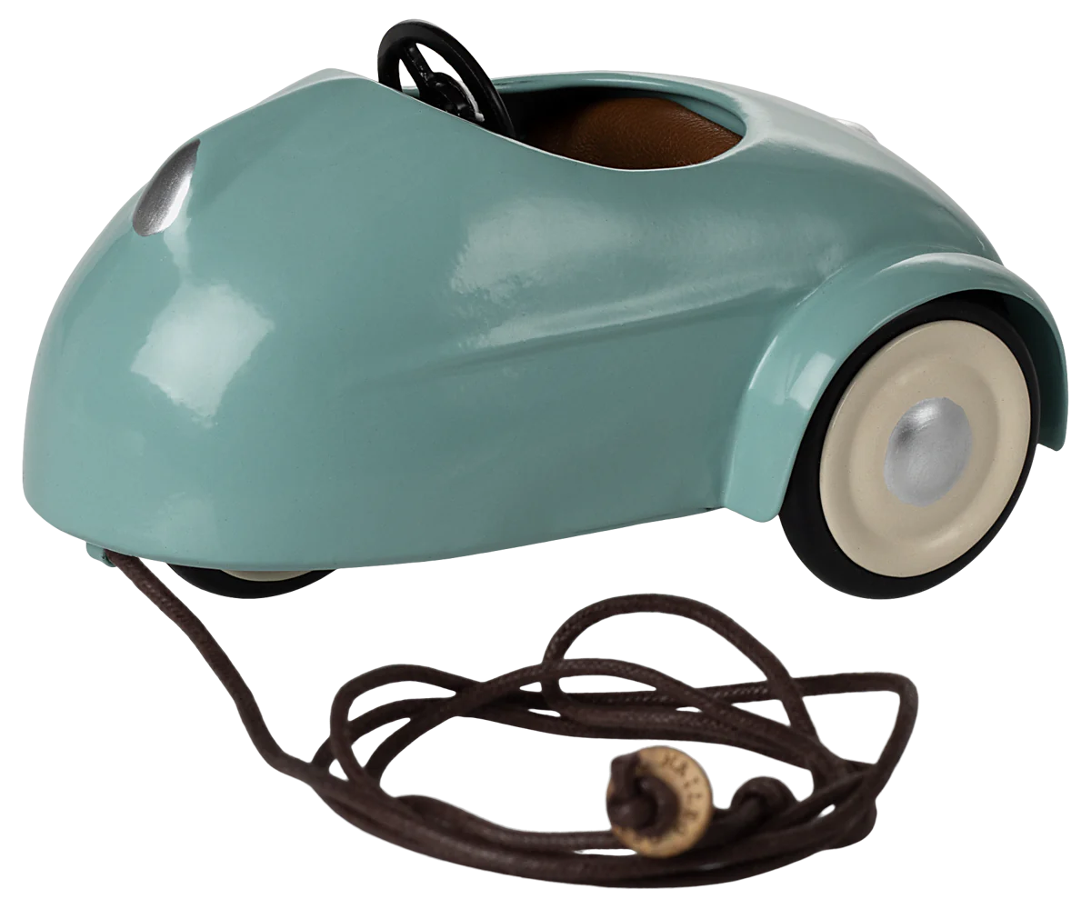A light blue toy car with a metal body, rubber wheels, and a cotton interior, designed for play with a pull-string mechanism.