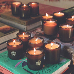 Candles in green holders on books with a warm glow