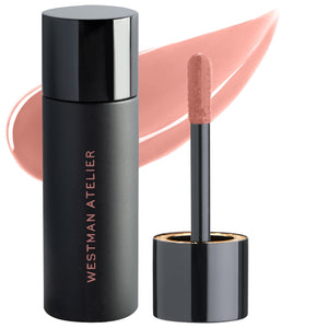 A photo of Westman Atelier Squeaky Clean Liquid Lip Balm with the container to the left and the applicator wand to the right, showing a translucent pink color.