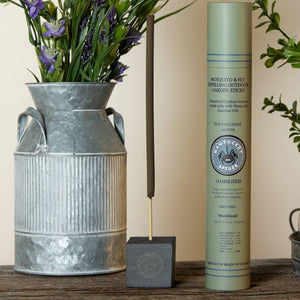 Mosquito and fly repelling outdoor garden sticks with a vase of flowers on a wooden surface.