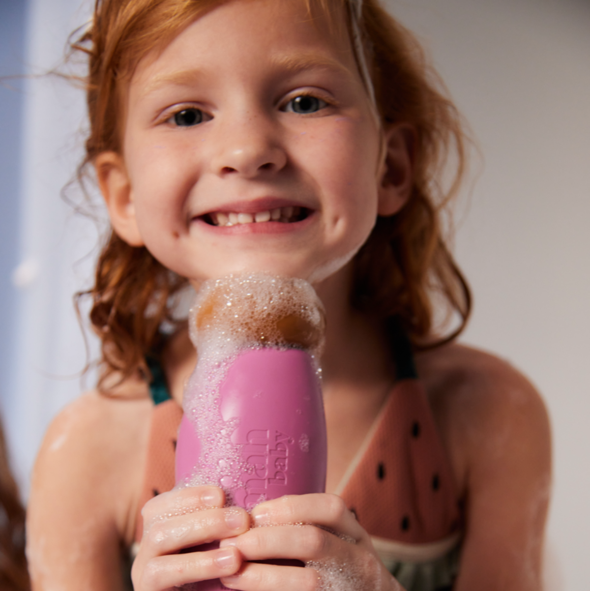 A child holding a nomad baby wash and shampoo. 