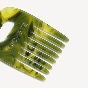 Green marbled hair comb on a white background