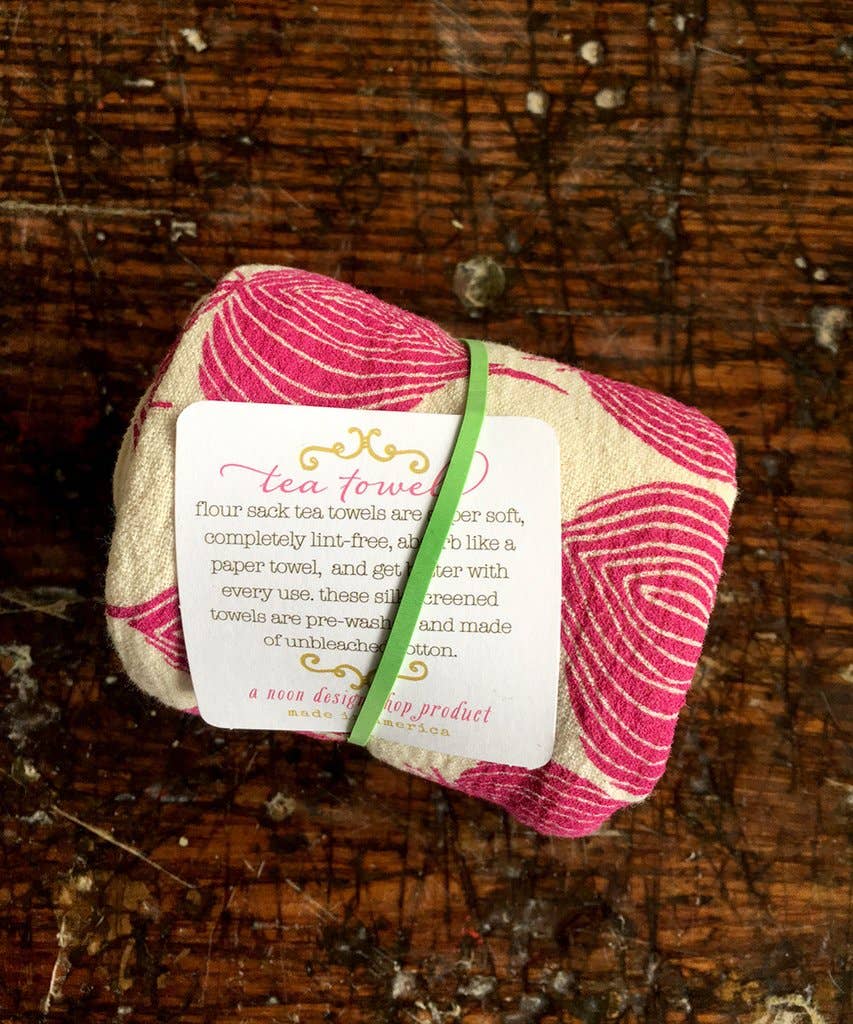 The Noon Designs red onion tea towel is white with bright red onions printed on it. 