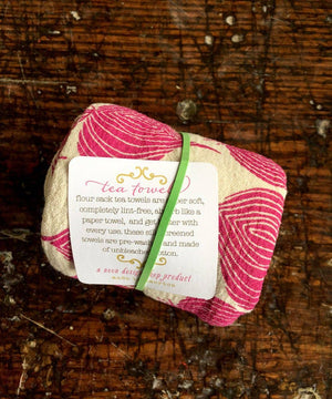 The Noon Designs red onion tea towel is white with bright red onions printed on it. 