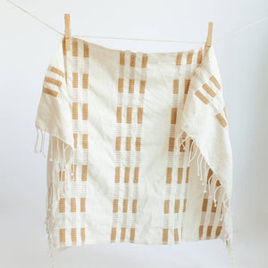 An ochre and white tea towel with a clothespin.