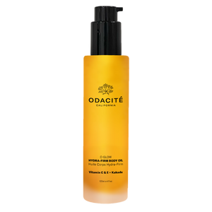 A clear pump bottle with yellow liquid inside, labeled C-Glow Hydra-Firm Body Oil by ODACITE.