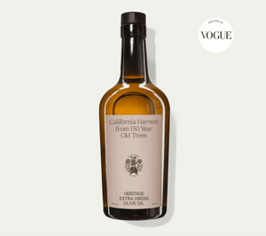 A bottle of Flamingo Estate Heritage Extra Virgin Olive Oil, with a label showing the brand and product name, on a white background with a 'California Harvest' text overlay and a 'Vogue' magazine logo in the top right corner.