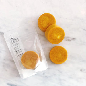 Three yellow circular objects on a marble surface with a white label.