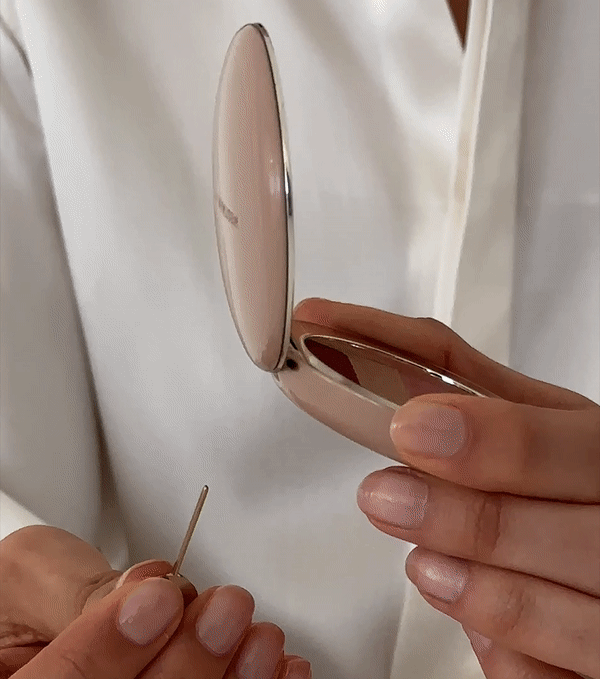 A person refilling a makeup compact