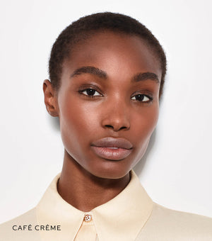 Woman wearing a beige shirt with 'Café Crème' text on a light background