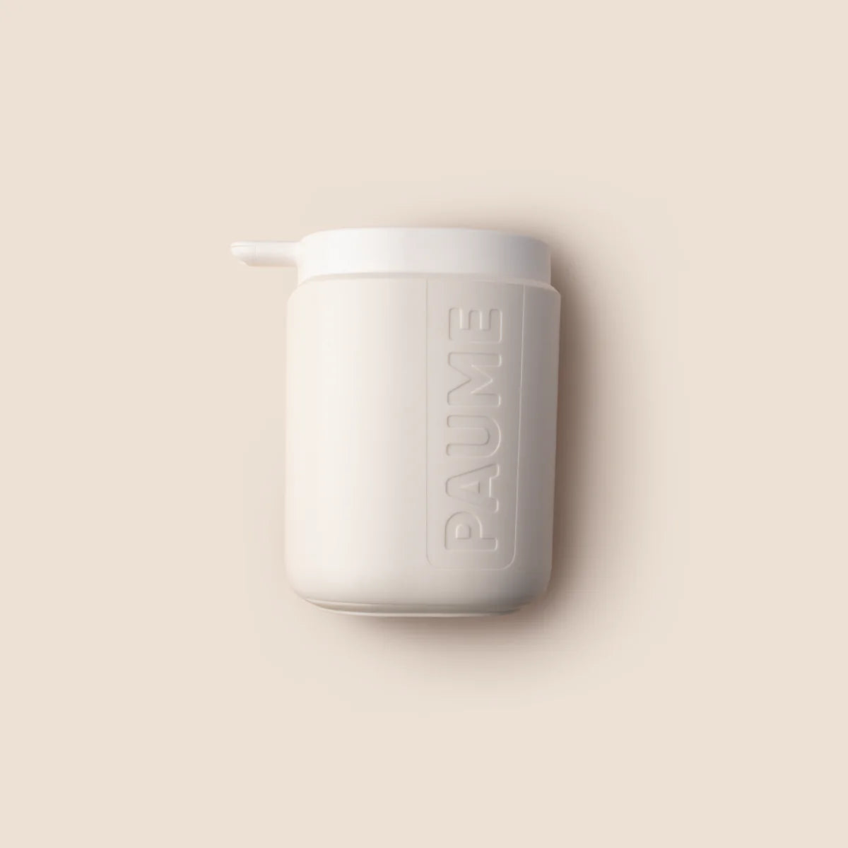 A white pump bottle with the brand name 'paume' printed on it, against a beige background.