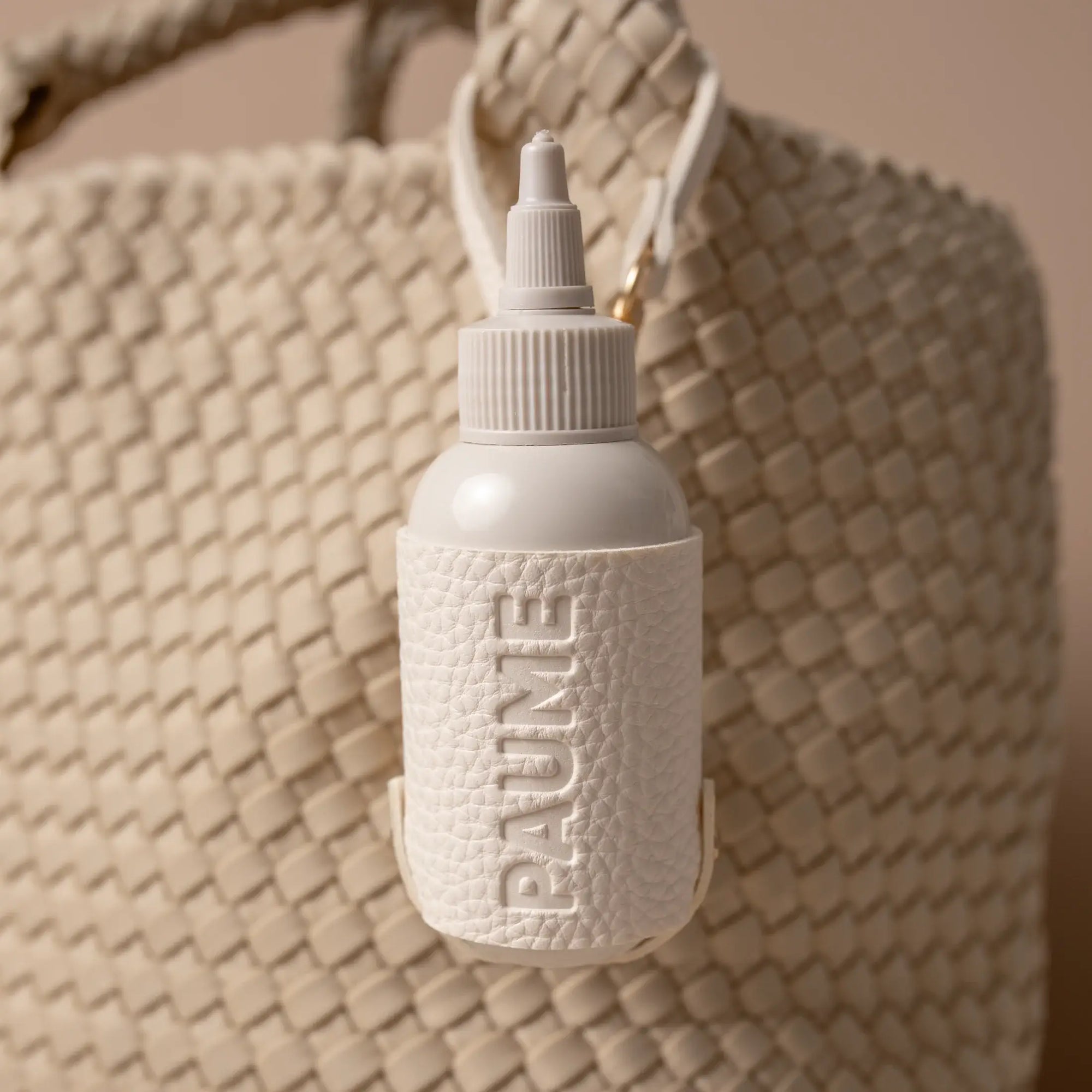 White textured bottle with 'BAUNI' branding on a woven surface