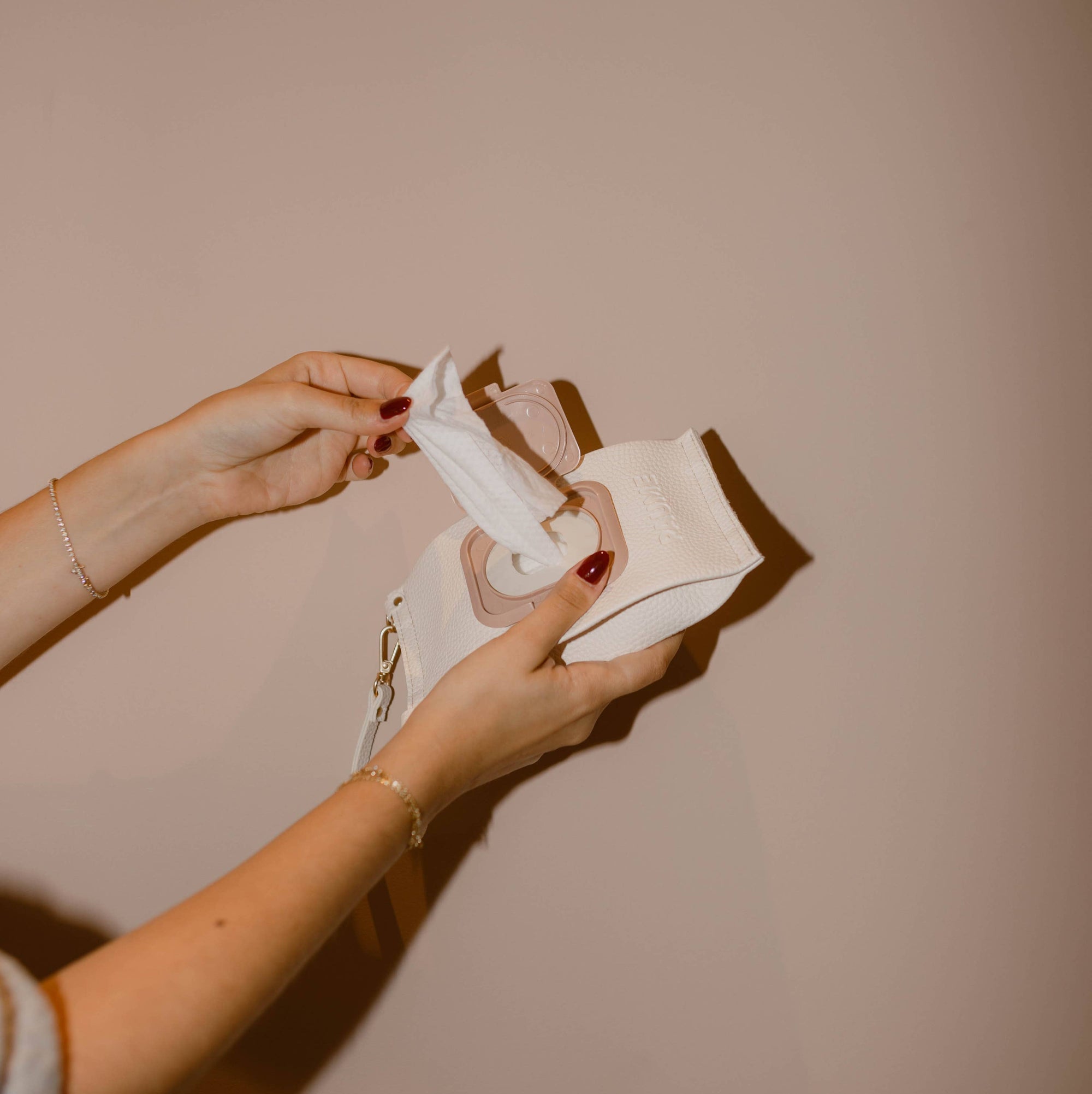 A person holding a package of Paume cleansing hand and body wipes.