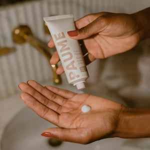 A person applying the Paume Probiotic Hand Cream to their palm