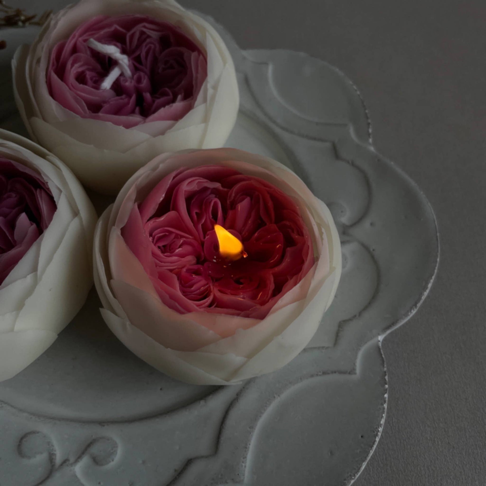 Peony candles on a white saucer. 