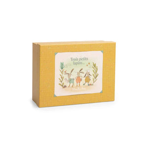 A yellow box with three rabbits on it and the words "Trois Petits Lapins."